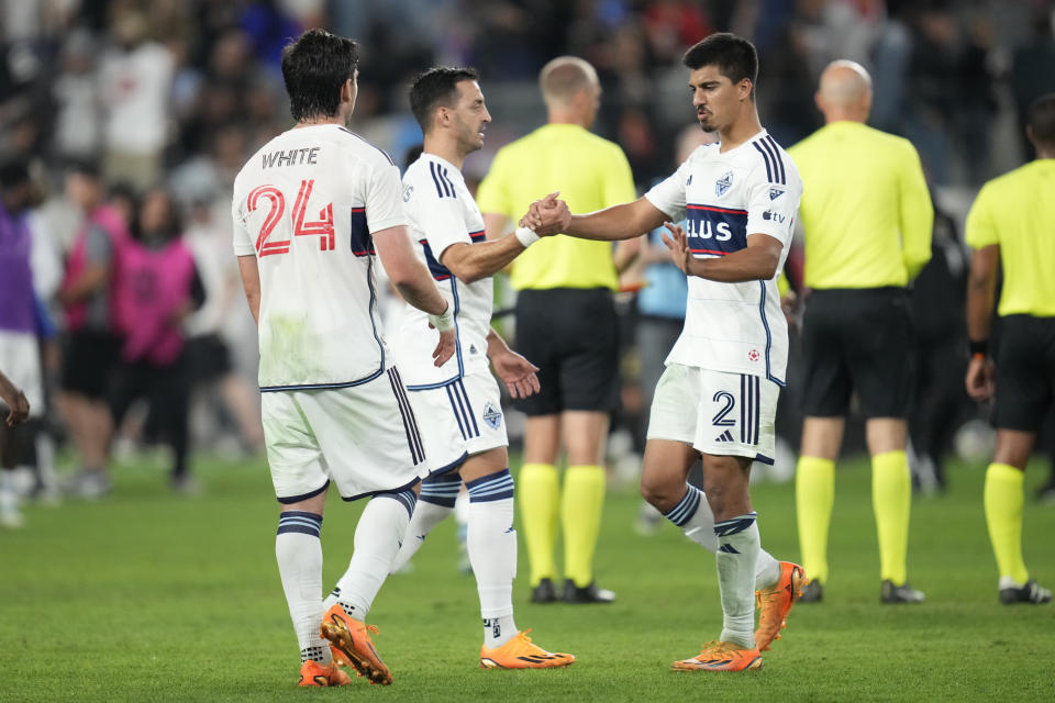 Vancouver Whitecaps forward Brian White (24), defender Luís Martins, and defender Mathías Laborda (2) celebrate after a 3-2 win over Los Angeles FC in an MLS soccer match in Los Angeles, Saturday, June 24, 2023. (AP Photo/Ashley Landis)