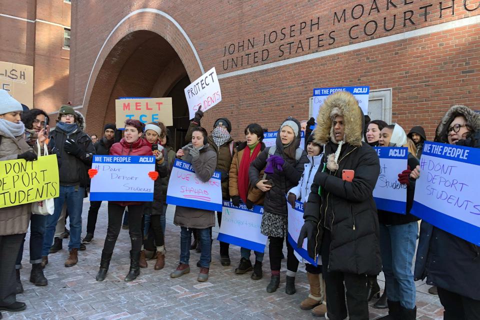 Protesters stand outside the federal courthouse where a hearing was scheduled for Northeastern University student Shahab Dehghani, Tuesday, Jan. 21, 2020, in Boston. Dehghani arrived on a flight into Boston on Monday but was detained by U.S. Customs and Border Patrol at Logan International Airport and then was deported. (AP Photo/Philip Marcelo)