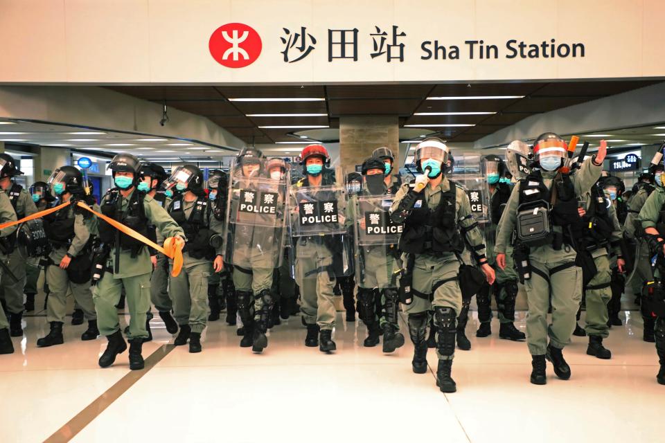 Riot police enter the shopping mall to disperse the protesters during Labor Day in Hong Kong, Friday, May 1, 2020 amid the coronavirus COVID-19 pandemic. Hong Kong police deployed pepper spray during a protest in a Hong Kong shopping mall on Friday, as they dispersed over a hundred protesters who gathered to sing and chant pro-democracy slogans.