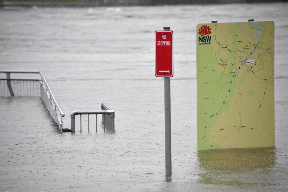 This picture shows sign boards in a flooded park along the overflowing Nepean river in Penrith suburb on March 21, 2021, as Sydney braced for its worst flooding in decades after record rainfall caused its largest dam to overflow and as deluges prompted mandatory mass evacuation orders along Australia's east coast. (Photo by Saeed KHAN / AFP) (Photo by SAEED KHAN/AFP via Getty Images)