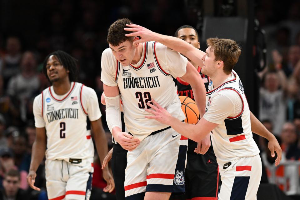 Connecticut guard Cam Spencer (12) reacts with center Donovan Clingan (32) during their defeat of San Diego State in the semifinals of the East Regional of the 2024 NCAA men's tournament at TD Garden.