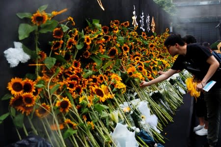 Pro-democracy activists lay sunflowers at a memorial site for anti-extradition bill protester Marco Leung, who died after falling from a scaffolding at the Pacific Place complex while protesting, in Hong Kong
