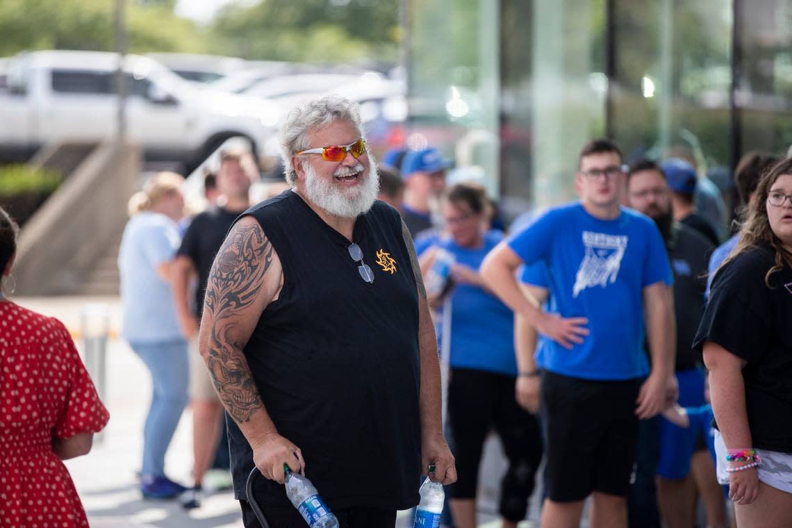 Alan Phillips helps distribute water bottles to fans waiting in line outside Rupp Arena before Tuesday night’s fundraiser.