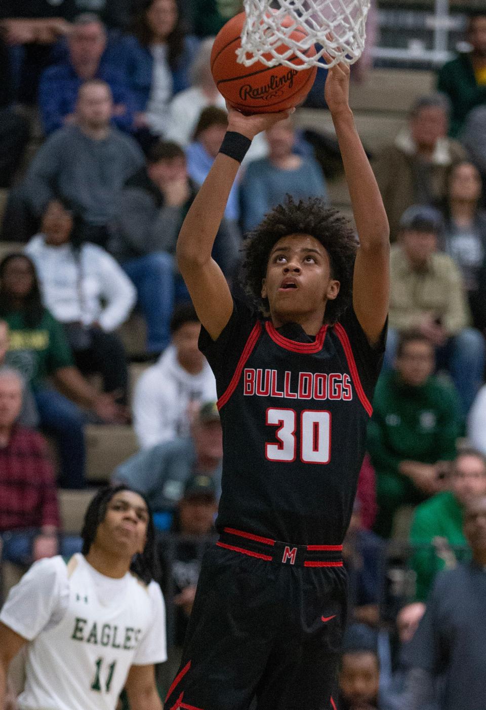 McKinley's Reed Sims Jr. (30) scores as GlenOak's Kenny Scott looks on during a boys high school basketball game on Tuesday, January 24, 2023.