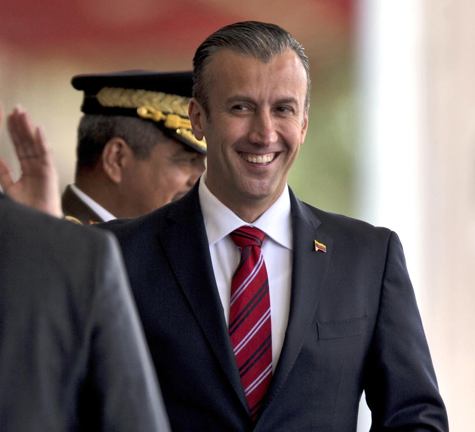 FILE - In this Feb. 1, 2017 photo, Venezuela's Vice President Tareck El Aissami, right, is saluted by Bolivarian Army officer upon his arrival for a military parade at Fort Tiuna in Caracas, Venezuela. Charges were unsealed Friday, March 8, 2019, against the former Venezuelan vice president in New York federal court as authorities accused him of using his office to aid international drug traffickers. (AP Photo/Fernando Llano, File)