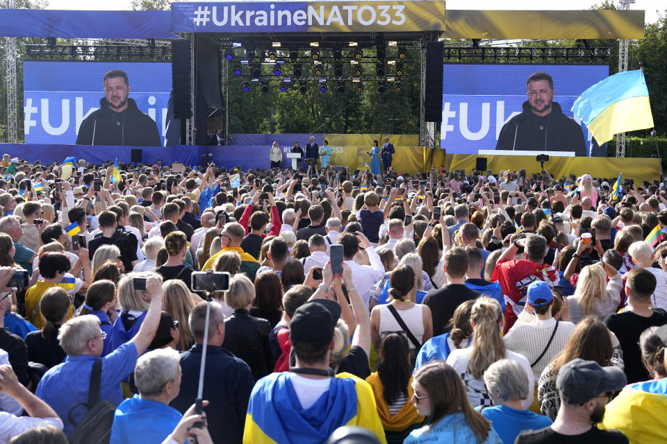 Ukraine's President Volodymyr Zelenskyy addresses the crowd from a stage and on a giant video screen during an event on the sidelines of a NATO summit in Vilnius, Lithuania, Tuesday, July 11, 2023. Ukrainian President Volodymyr Zelenskyy on Tuesday blasted as "absurd" the absence of a timetable for his country's membership in NATO, injecting harsh criticism into a gathering of the alliance's leaders that was intended to showcase solidarity in the face of Russian aggression. (AP Photo/Pavel Golovkin)