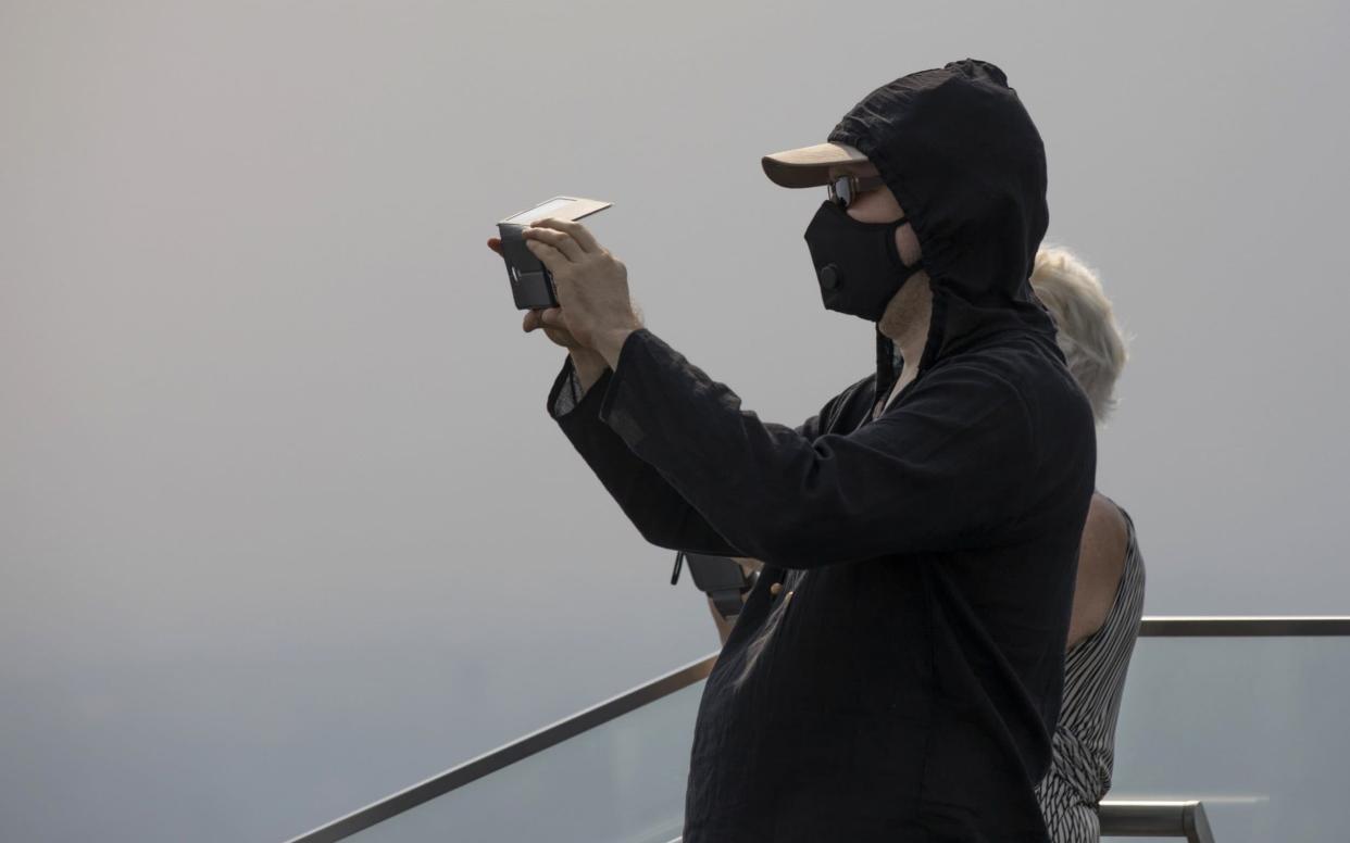 A tourist wears a protective mask in Bangkok, as pollution reaches dangerous levels in the Thai capital  - Bloomberg