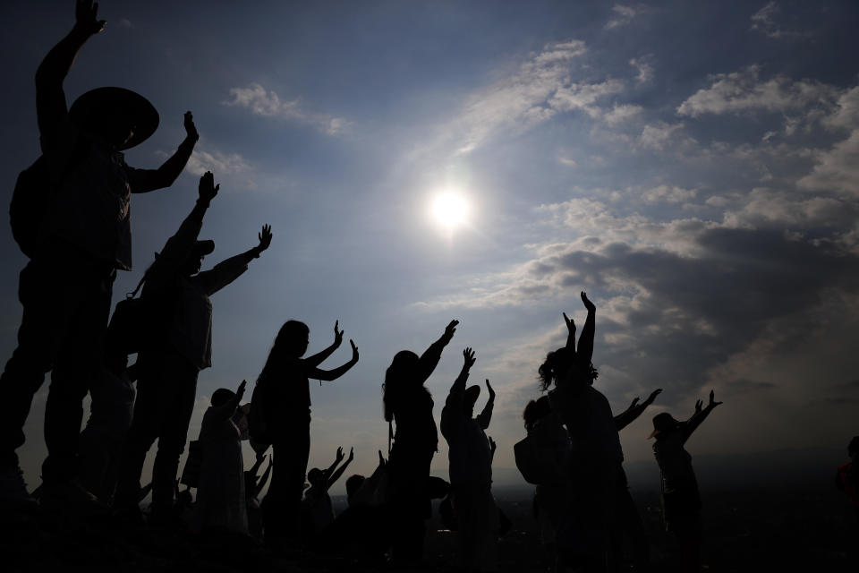 FILE - Visitors hold their hands out to receive the sun's energy as they celebrate the Spring equinox atop the Pyramid of the Sun in Teotihuacan, Mexico, Thursday, March 21, 2019. Spring gets its official start Tuesday, March 19, 2024, in the Northern Hemisphere. On the equinoxes, the Earth's axis and orbit line up so both hemispheres get the same amount of sunlight. (AP Photo/Marco Ugarte, File)