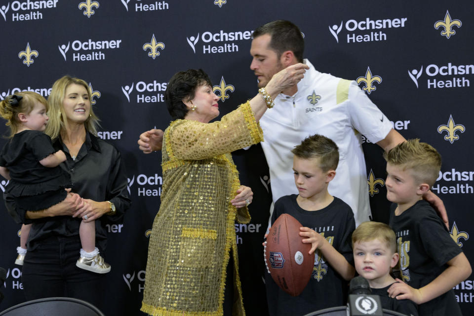 Derek Carr, the new quarterback of the New Orleans Saints, is welcomed by owner Gayle Benson alongside his family including wife Heather, left, daughter, Brooklyn, and sons, Dallas, Deker, and Deakon Carr, during a NFL footbal press conference at the team's training facility in Metairie, La., Saturday, March 11, 2023. (AP Photo/Matthew Hinton)