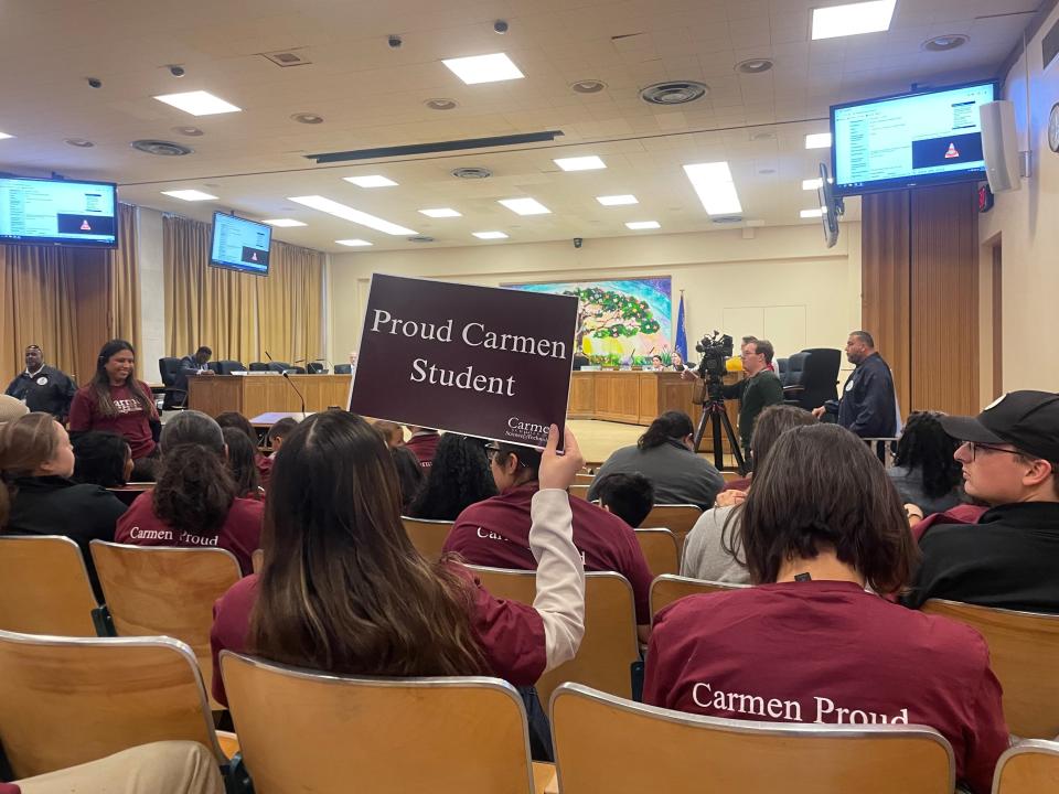 Carmen families and staff wear school shirts at a Milwaukee School Board meeting April 23 to send a signal that they don't want to leave their current buildings.