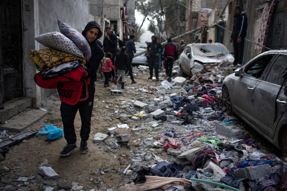 Palestinians look at the destruction after an Israeli airstrike in Rafah, Gaza Strip, Friday, Feb. 9, 2024.