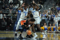 UCLA guard Brandon Williams (5) and UCLA guard Dylan Andrews (2) guard Oregon State guard Jordan Pope (0) during the first half of an NCAA college basketball game in the first round of the Pac-12 tournament Wednesday, March 13, 2024, in Las Vegas. (AP Photo/John Locher)