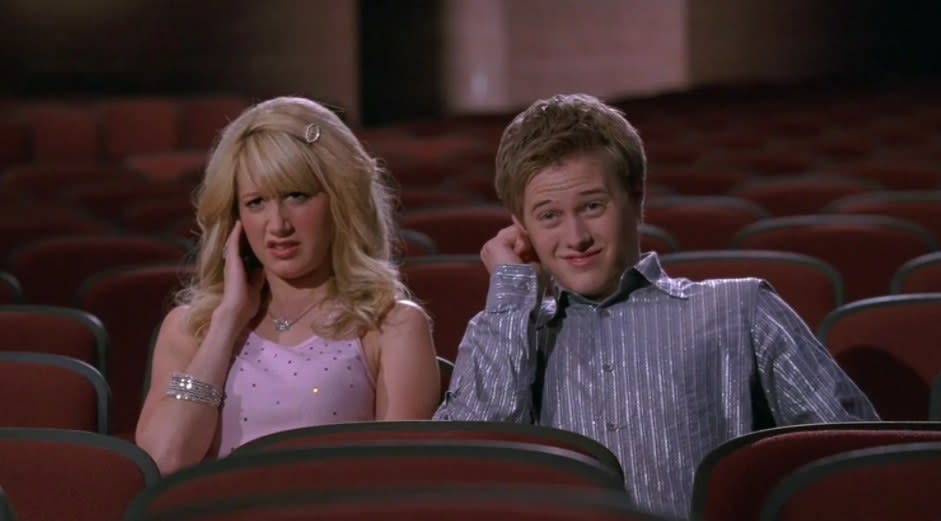 Sharpay and Ryan sit in an empty theatre covering the ear and pulling uncomfortable faces