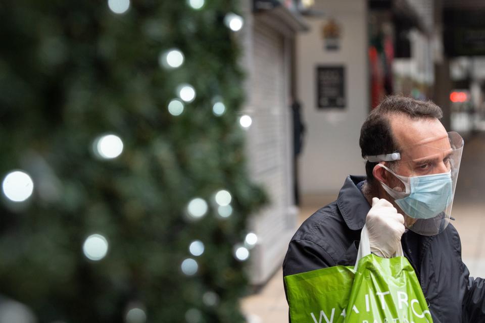 <p>A man wears a face covering while on Oxford Street</p> (PA)