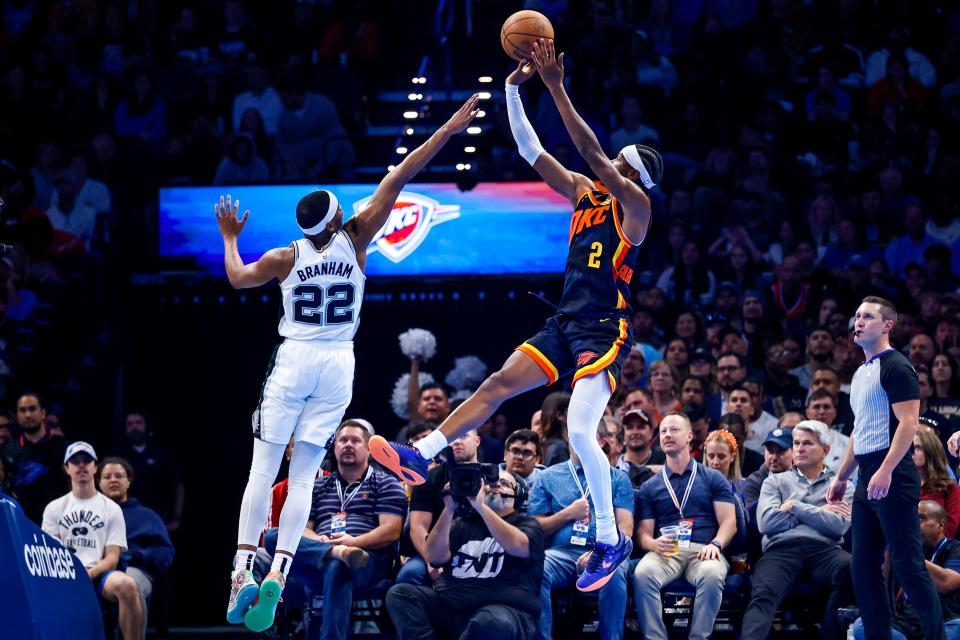 Thunder guard Shai Gilgeous-Alexander (2) jumps to shoot over SPurs guard Malaki Branham (22) in the third quarter of a 123-87 win Tuesday at Paycom Center.