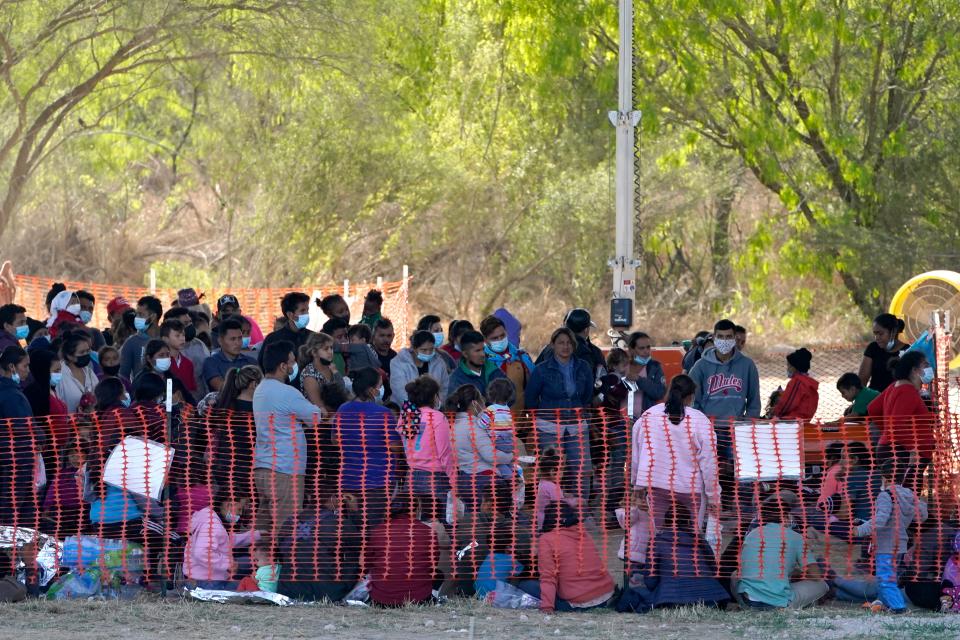 Migrants are seen in custody at a U.S. Customs and Border Protection processing area under the Anzalduas International Bridge, Friday, March 19, 2021, in Mission, Texas. A surge of migrants on the Southwest border has the Biden administration on the defensive. The head of Homeland Security acknowledged the severity of the problem Tuesday but insisted it's under control and said he won't revive a Trump-era practice of immediately expelling teens and children. An official says U.S. authorities encountered nearly double the number children traveling alone across the Mexican border in one day this week than on an average day last month. (AP Photo/Julio Cortez)