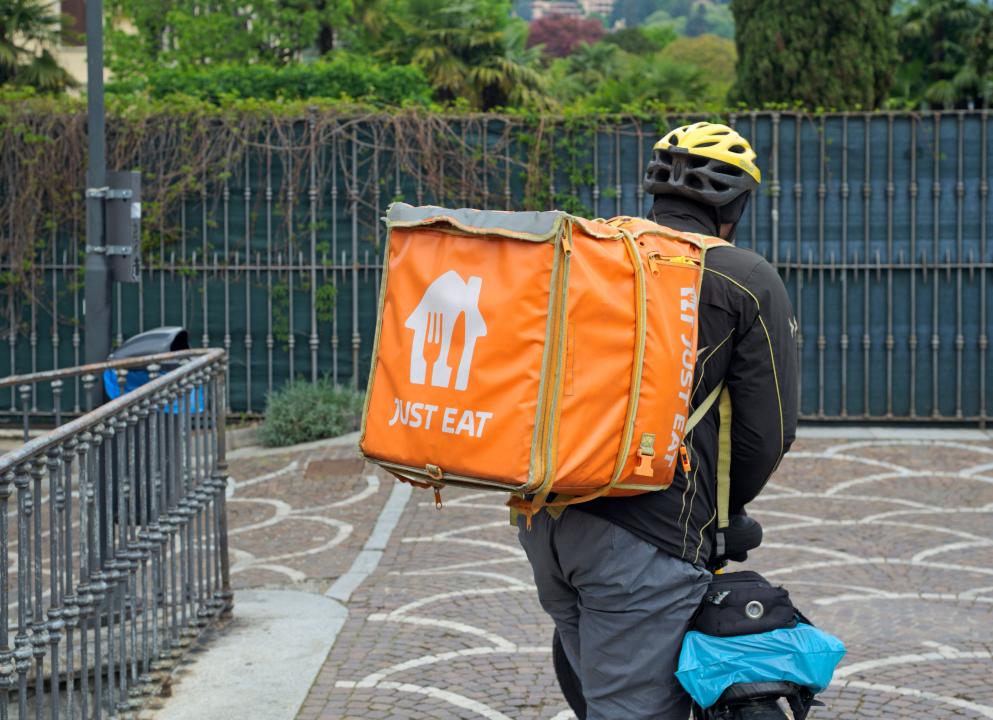 Just Eat courier holding bike, Como, Italy