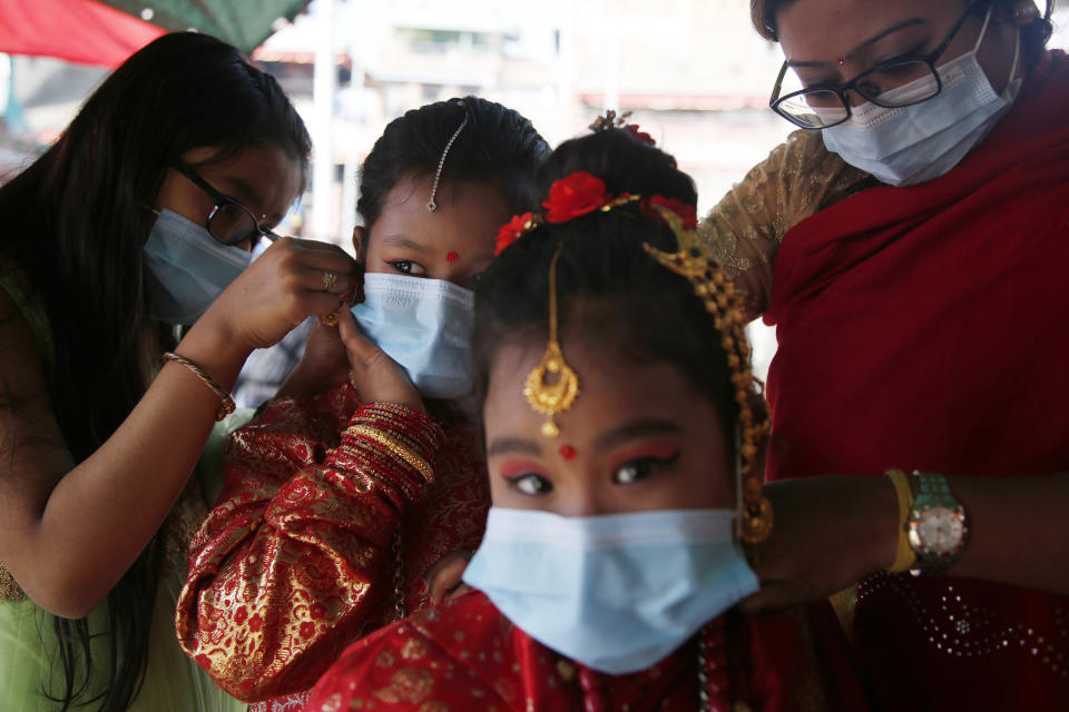 Young Newari girls prepare for an Ihi ceremony in Kathmandu, Nepal, Friday, Dec. 4, 2020. Ihi is a two-day ceremony performed for girls who have not reached puberty and involves purification rituals and marriage rituals with the Bael (or wood apple). Newari girls are married thrice in their life, to the bael fruit and the sun before marrying a human. (AP Photo/Niranjan Shrestha)