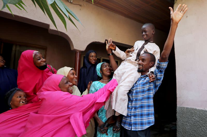 FILE PHOTO: Muhammed Bello, a rescued student, is carried by his father as his relatives celebrate after he retuned home in Kankara