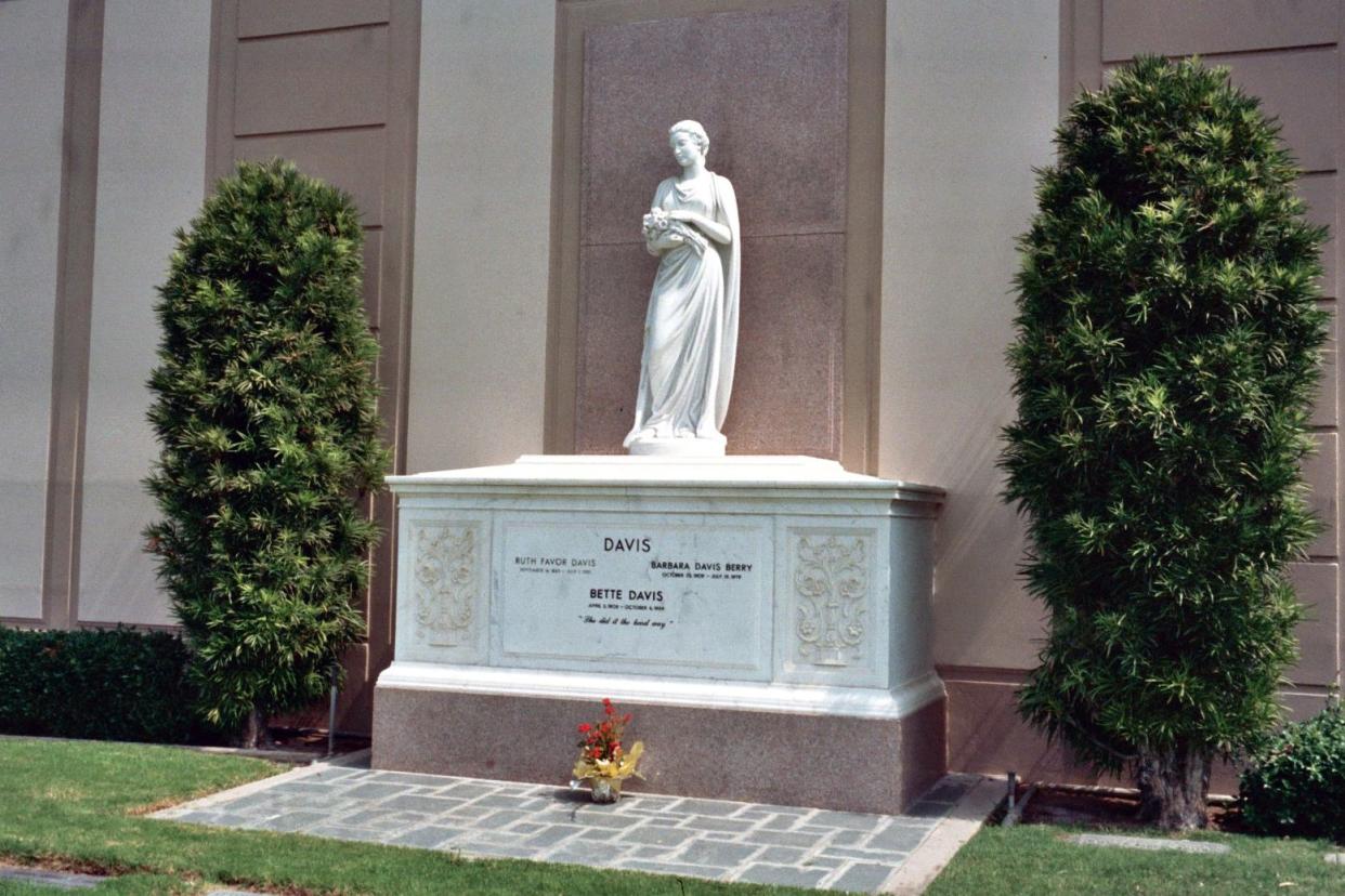 Bette Davis' Tomb in the Forest Lawn Memorial Park, Glendale, California against a wall on a bright sunny day