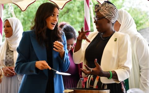 The Duchess of Sussex in animated conversation at the cookbook launch - Credit: BEN STANSALL /AFP