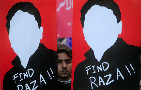 A demonstrator holds placards calling for the release of Raza Mehmood Khan, a member of Aghaz-i-Dosti (Start of Friendship), a group that works on peace building between Pakistan and India, during a protest in Lahore, Pakistan December 11, 2017. REUTERS/Mohsin Raza