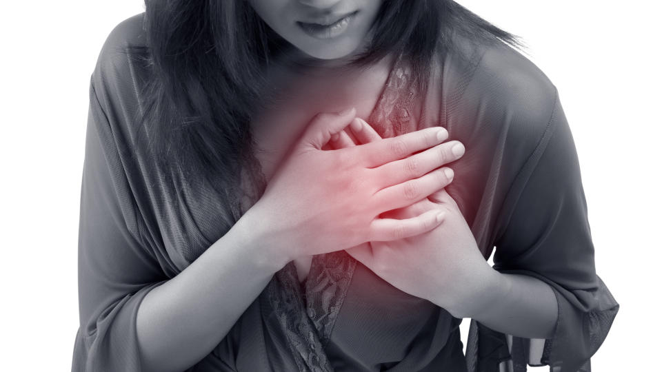 Woman is clutching her chest, acute pain possible heart attack