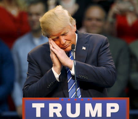 Republican presidential candidate Donald Trump gestures as if he is sleeping while talking about his opponent Jeb Bush during a Trump for President campaign rally in Raleigh, North Carolina December 4, 2015. REUTERS/Jonathan Drake