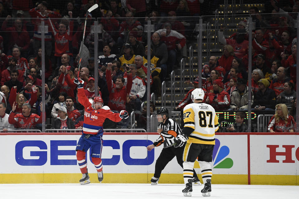 Washington Capitals left wing Jakub Vrana (13) celebrates his goal as Pittsburgh Penguins center Sidney Crosby (87) skates by during the first period of an NHL hockey game, Sunday, Feb. 23, 2020, in Washington. (AP Photo/Nick Wass)