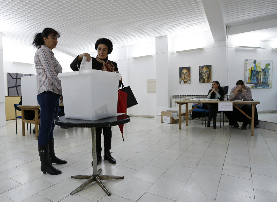 A woman casts her ballot for a general election at a poling station in the Bosnian town of Laktasi, northwest of Sarajevo, Bosnia, Sunday, Oct. 7, 2018. Sunday's vote is seen as a test of whether Bosnia will move toward integration in the European Union and NATO or remain entrenched in war-era rivalries. (AP Photo/Darko Vojinovic)