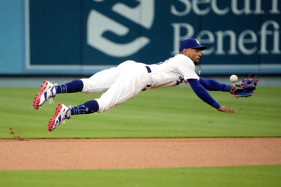 Los Angeles Dodgers second baseman Mookie Betts can't get to a ball hit for a single by Atlanta Braves' Ronald Acuna Jr. during the first inning of a baseball game Thursday, Aug. 31, 2023, in Los Angeles. (AP Photo/Mark J. Terrill)