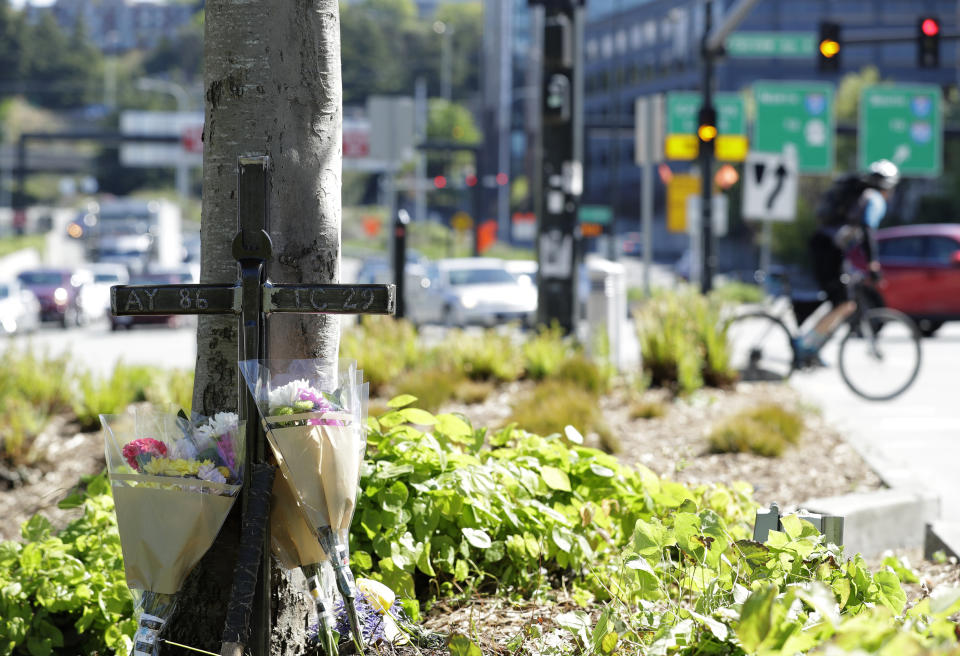 An iron cross bearing the numbers of Ironworkers Local union chapters from Portland and Seattle stands next to flowers, Monday, April 29, 2019, in Seattle at a memorial on a median across the street from where a construction crane collapsed and fell Saturday, killing four people, two of whom were ironworkers. (AP Photo/Ted S. Warren)