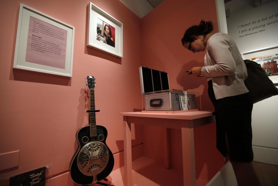 A guitar that used to belong to Amy Winehouse is seen at an exhibition entitled "Amy Winehouse: A Family Portrait" in London's Jewish Museum, Tuesday, July 2, 2013. The exhibition aims to reveal an intimate side of the late soul diva. She was, in the words of her older brother Alex, "simply a little Jewish kid from North London with a big talent." It includes a trove of items from the singer's London childhood, her stage-school years and her short but stratospheric career in music _ from her first guitar to a posthumous Grammy Award. By the time she died in 2011 at the age of 27, Winehouse was a star, a larger-than-life figure whose battles with drugs and alcohol, splashed across front pages around world, sometimes seemed to overshadow her talent. (AP Photo/Lefteris Pitarakis)