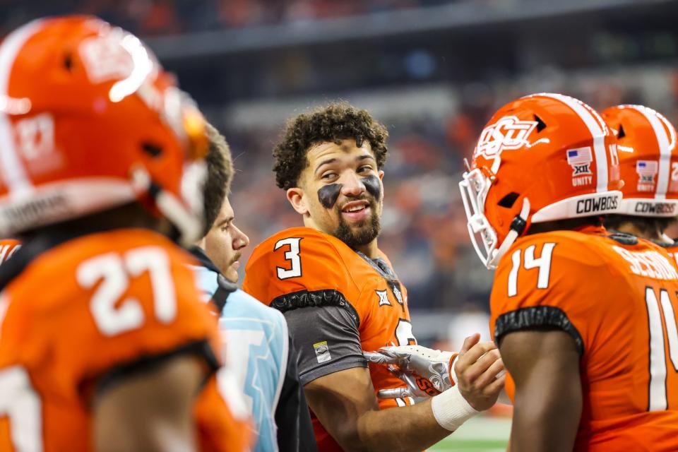 OSU quarterback Spencer Sanders (3) talks with teammates before last season's Big 12 championship game against Baylor at AT&T Stadium in Arlington, Texas.