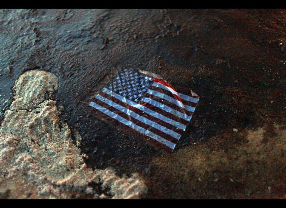 An American flag lays in a slick of oil that washed ashore from the Deepwater Horizon oil spill in the Gulf of Mexico on July 4, 2010 in Gulf Shores, Alabama. The oil spill may have a huge negative economic impact on gulf coast businesses during what should be a busy 4th of July. Millions of gallons of oil have spilled into the Gulf since the April 20 explosion on the drilling platform.  (Joe Raedle, Getty Images)