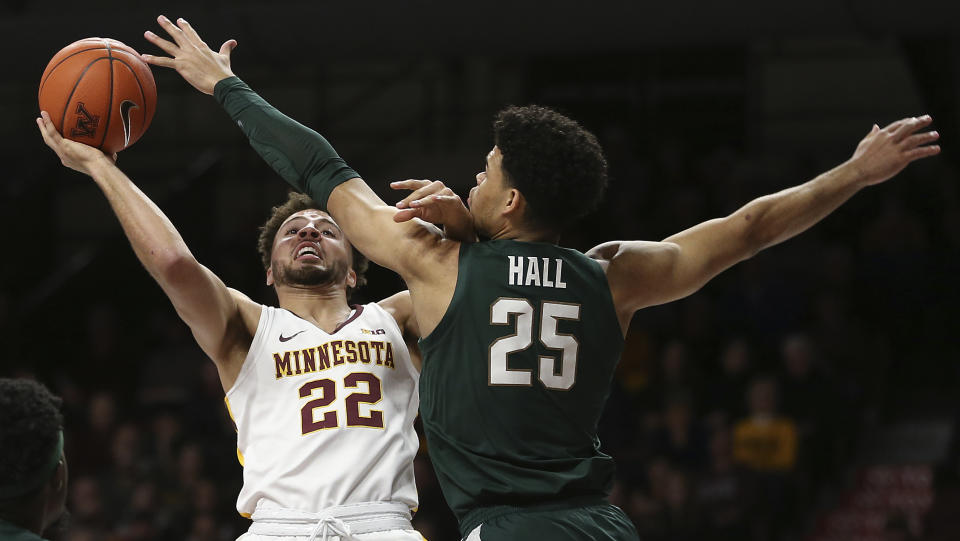 Minnesota's Gabe Kalscheur (22) shoots over Michigan State's Malik Hall during an NCAA college basketball game Sunday, Jan. 26, 2020, in Minneapolis. (AP Photo/Stacy Bengs)