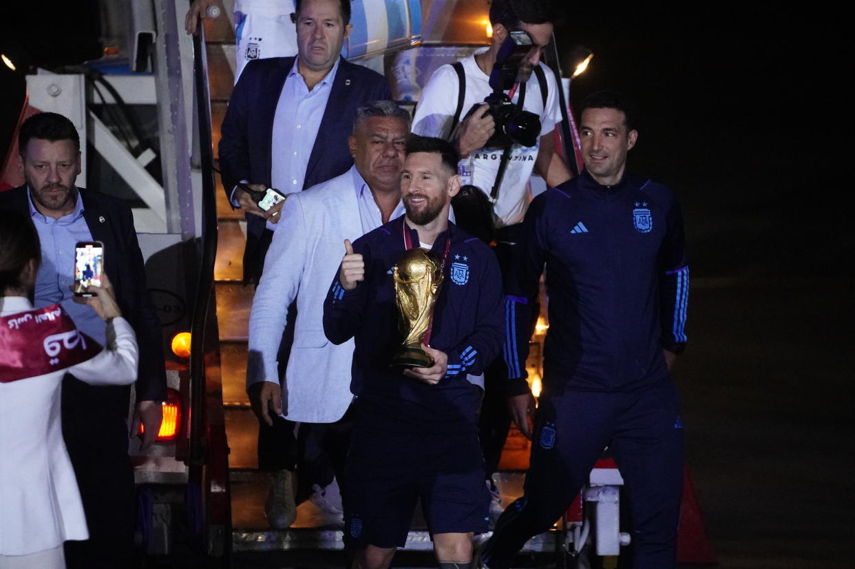 BUENOS AIRES, ARGENTINA - DECEMBER 20: Lionel Messi of Argentina and head coach Lionel Scaloni of Argentina leave the plane with the World Cup trophy during the arrival of the Argentina men's national football team after winning the FIFA World Cup Qatar 2022 on December 20, 2022 in Buenos Aires, Argentina. (Photo by Franco Dergarabedian/DeFodi Images via Getty Images)