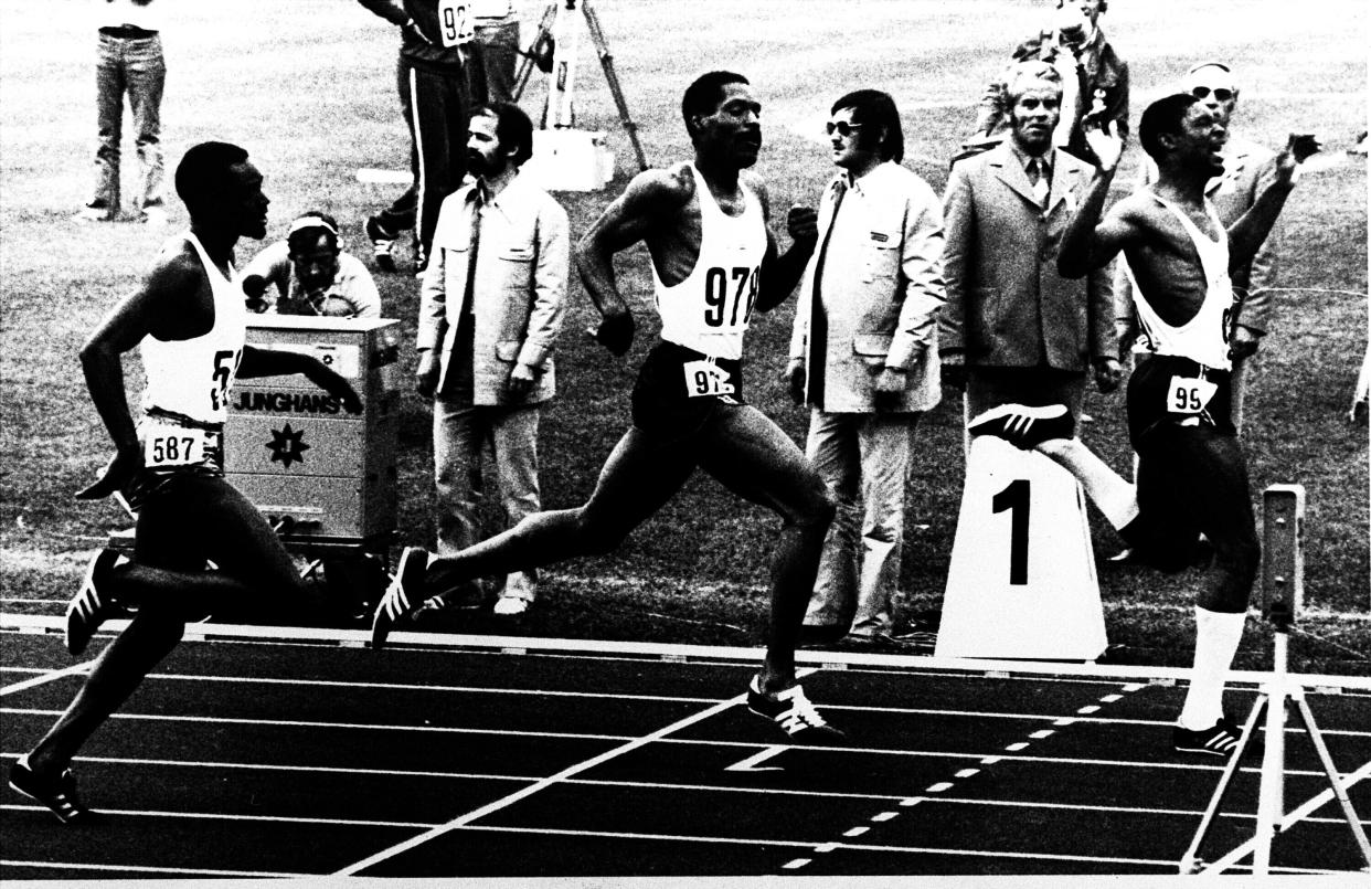 United States' Vince Matthews, right, raises his arms as he wins the final of the Olympic Games 400-meter dash, edging out teammate Wayne Collett, center. Julius Sang, left, of Kenya, finished third on Sept 7, 1972 in Munich. (AP)