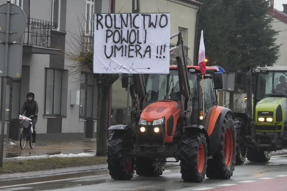 Protesting farmers in Poland are slow-driving their tractors on a road in Deblin, Poland, Wednesday, Jan. 24, 2024 to disturb traffic and draw attention to their disagreement to European Union regulations. Such protests were held across Poland. (AP Photo/Czarek Sokolowski)
