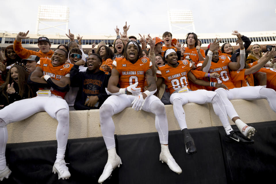 Left to right: Oklahoma State's Jaden Nixon, Ollie Gordon II, Brennan Presley, and Rashod Owens celebrate after an NCAA college football game against Kansas in Stillwater, Okla., Saturday, Oct. 14, 2023. (AP Photo/Mitch Alcala)