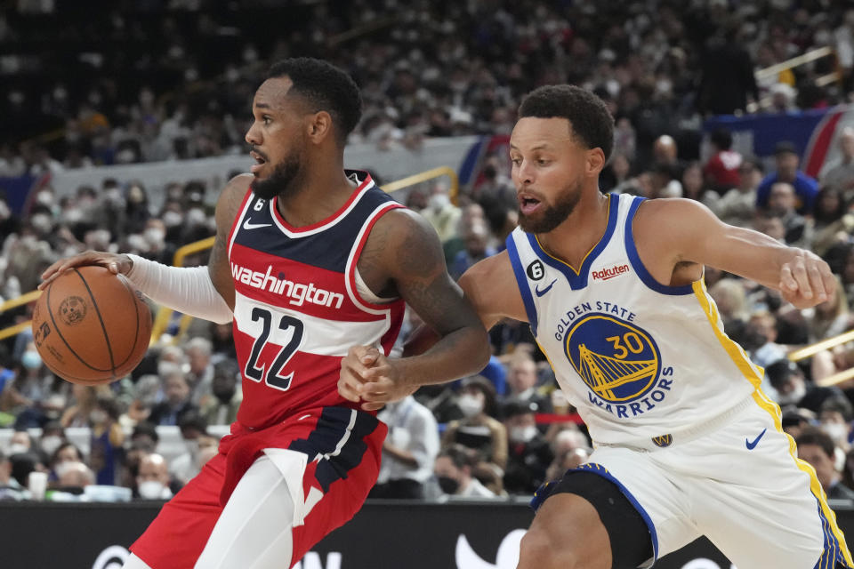 Washington Wizards' Monte Morris, left, plays against Golden State Warriors' Stephen Curry during their preseason NBA basketball game, Friday, Sept. 30, 2022, at Saitama Super Arena, in Saitama, north of Tokyo. (AP Photo/Eugene Hoshiko)