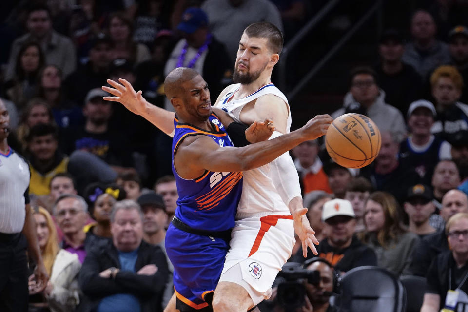 Phoenix Suns' Chris Paul, left, collides with Los Angeles Clippers' Ivica Zubac as he passes the ball during the first half of an NBA basketball game Thursday, Feb. 16, 2023, in Phoenix. (AP Photo/Darryl Webb)