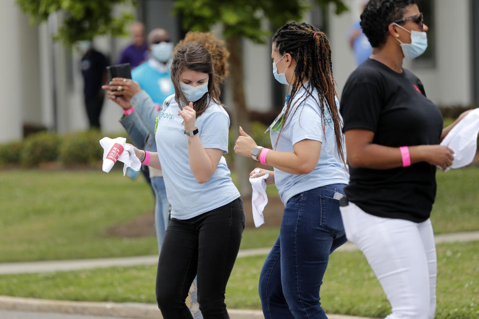 Healthcare workers at New Orleans East Hospital wave handkerchiefs and dance to a jazz serenade, as a tribute for their care of COVID-19 patients, by the New Orleans Jazz Orchestra, outside the hospital in New Orleans, Friday, May 15, 2020. A New York woman collaborated with the New Orleans Jazz Orchestra to put on what she calls a stimulus serenade to give moral support to front-line hospital workers and COVID-19 patients in New Orleans (AP Photo/Gerald Herbert)