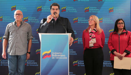 Venezuela's President Nicolas Maduro talks to the media after casting his vote, next to Venezuela's Communications and Information Minister Jorge Rodriguez, his wife Cilia Flores, and Venezuela's Vice President Delcy Rodriguez, at a polling station during the municipal legislators election in Caracas, Venezuela December 9, 2018. Miraflores Palace/Handout via REUTERS