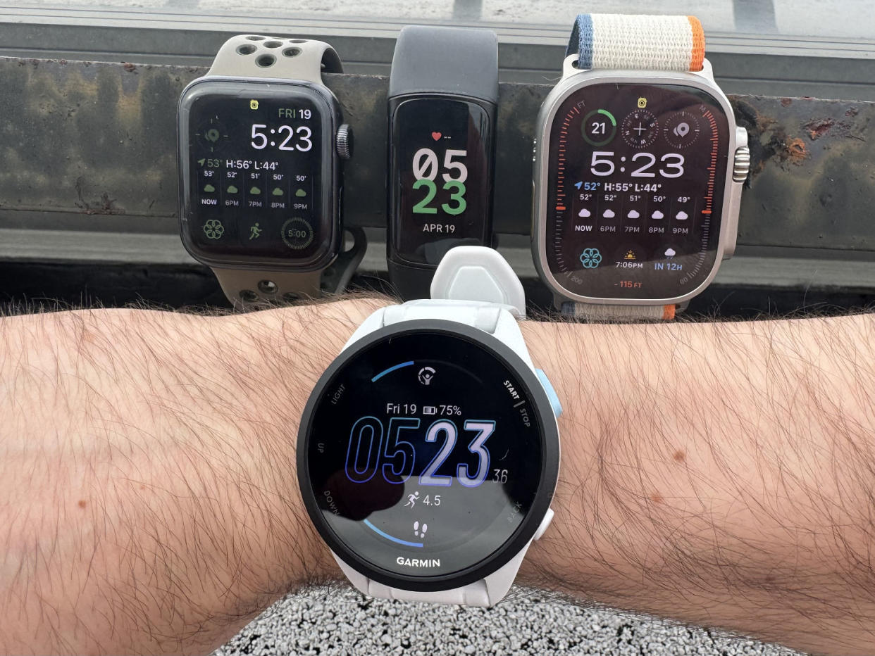 Close up shot of the Forerunner 165 (front) alongside the Apple Watch SE, Fitbit Charge 6 and Apple Watch Ultra 2 (back). (Courtesy Harry Rabinowitz)