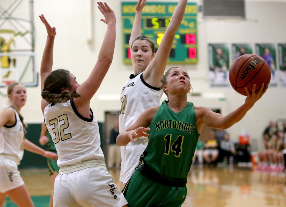 Northridge's Rielyn Goodwin (14) shoots over Penn’s Macy Little (32) and Anna Sachire (30) during the Northridge vs. Penn girls sectional basketball championship game Saturday, Feb. 3, 2024, at Northridge Middle School.