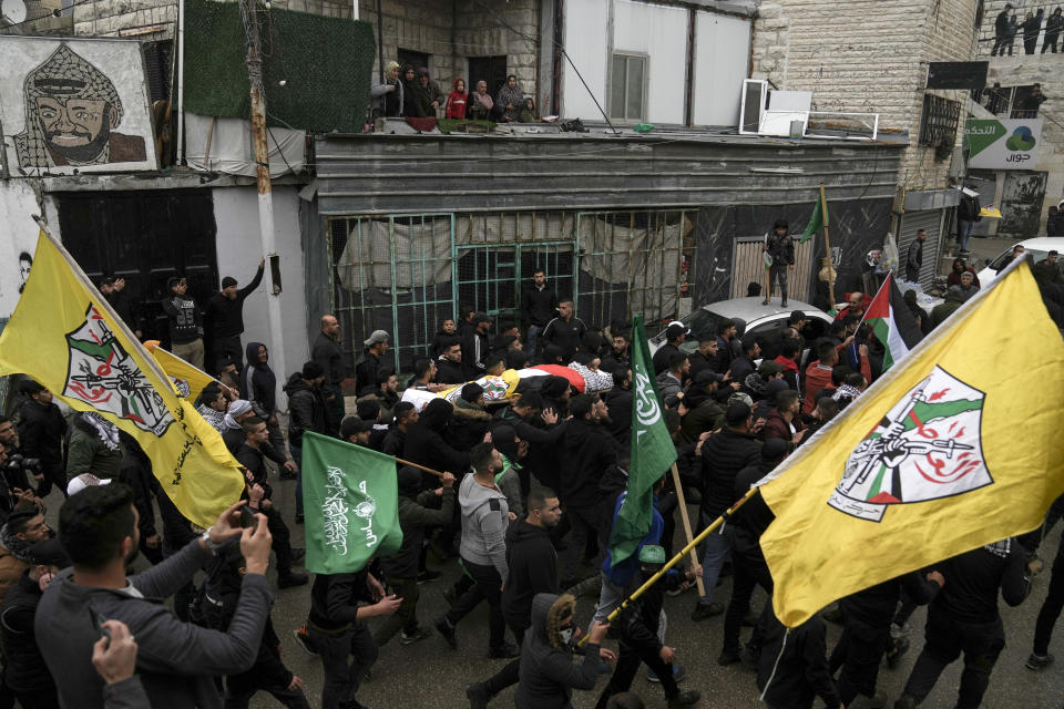 Palestinian mourners carry the body of Mufid Khalil during his funeral in the West Bank village of Beit Ummar, near Hebron, Tuesday, Nov. 29, 2022. Khalil was killed by Israeli fire in the occupied West Bank, the Palestinian Health Ministry said Tuesday. The Israeli military said soldiers shot at Palestinians who hurled rocks and improvised explosive devices and shot at the troops. (AP Photo/Mahmoud Illean)