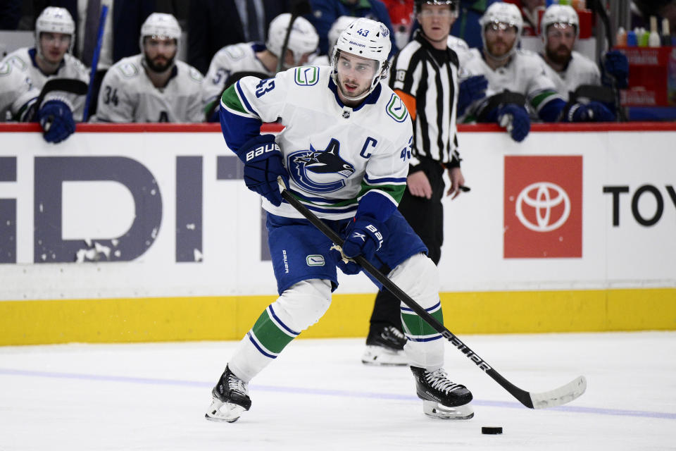 Vancouver Canucks defenseman Quinn Hughes (43) skates with the puck during the second period of an NHL hockey game against the Washington Capitals, Sunday, Feb. 11, 2024, in Washington. (AP Photo/Nick Wass)