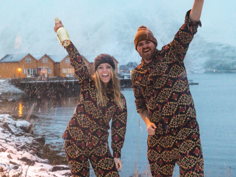 A woman and a man wearing matching pajamas in a snowy environment