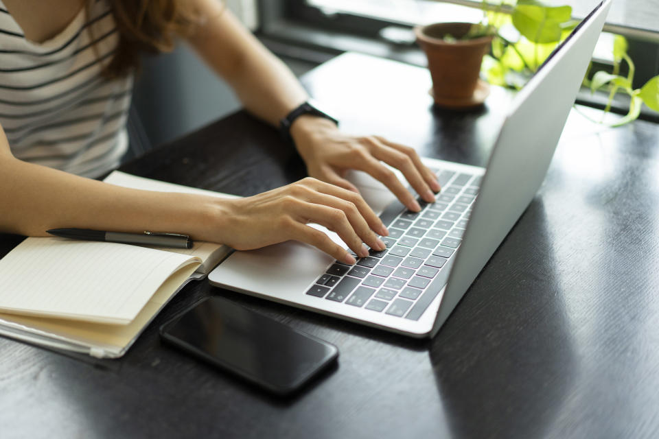 Person working on computers next to files